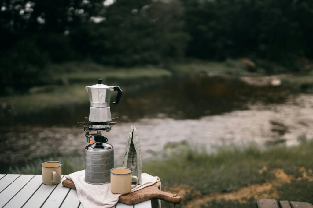 moka pot next to a mug on a wooden table